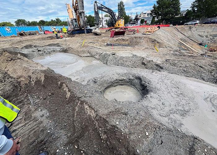 a large round hold filled with water in a dirt construction site